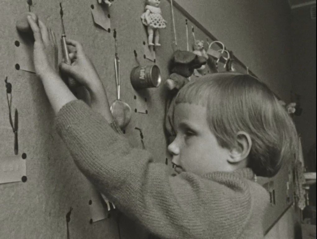 Niña tocando texturas y reconociendo objetos con su ficha en Braille. Blind kind (1964). Johan van der Keuken.